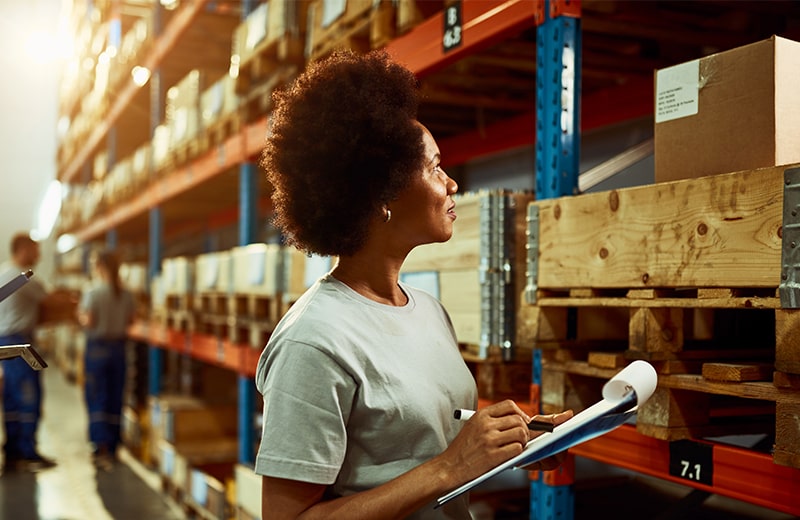 trust_0002_african-american-worker-writing-inventory-list-while-checking-stock-storage-room-min